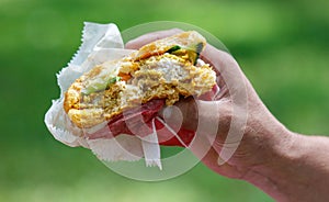 Close-up of a half-eaten burger in hand