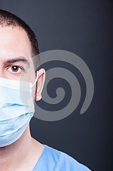 Close-up half face of doctor wearing scrubs and sterile mask