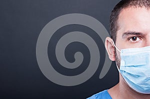 Close-up half face of medic wearing scrubs and sterile mask