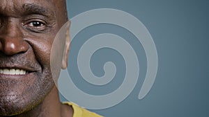 Close-up half male face with joyful expression mature african american man looking at camera smiling white healthy