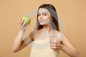 Close up half naked woman 20s with perfect skin, nude make up hold apple, water isolated on beige pastel wall background