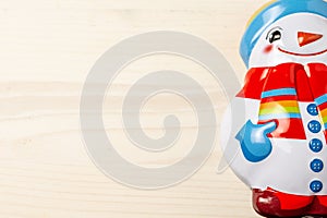 Close-up of half snowman figure, on white wooden table, horizontally