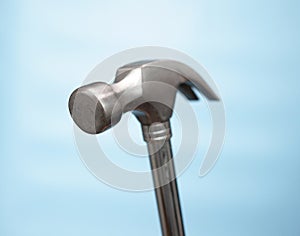 Close-up Hammer construction nail puller on a blue background. Imitation of hammering nails. Construction or renovation concept.