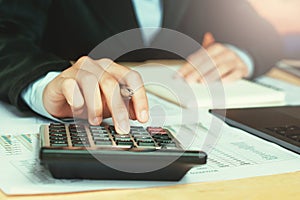 close up hand accountant using calculator with laptop. concept s photo