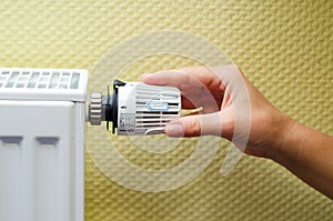 Close Up Of Hand Adjusting Heating Thermostat