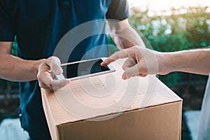 Close up of hand asian man using smartphone pressing screen to sign for delivery from the courier at home