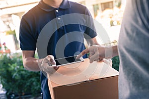 Close up of hand asian man using smartphone pressing screen to sign for delivery from the courier at home