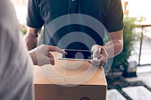 Close up of hand asian man using smartphone pressing screen to sign for delivery from the courier at home