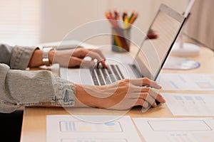 Close up hand Asian man working woman on the desk with her laptop, working from home