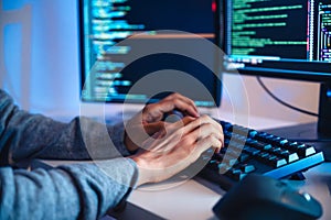 close up hand of Asian prompt engineer develop coding app with software data sitting in front of computer monitor at office