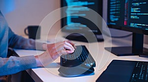 close up hand of Asian prompt engineer develop coding app with software data sitting in front of computer monitor at office