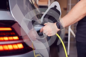 Pohľad zblízka na ruka pripojenie napájací kábel na ekologicky priateľský nula emisie elektrický auto 