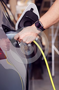Pohled zblízka na ruka připojení napájecí kabel na ekologicky přátelský nula emise elektrický auto 
