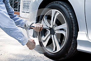 Close up hand of auto mechanic using wrench to changing a car tire.