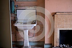 Close up of hand basin and oxidised water heater in derelict house built in 1930s deco style, Rayners Lane, Harrow UK photo