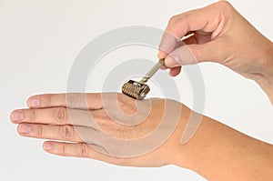 Close up of hand being massaged with derma roller