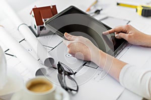 Close up of hand with blueprint and tablet pc