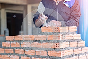 Close up hand of bricklayer worker installing bricks