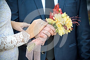 Close-up. Hand of bride and groom. Bride and groom hold hands. Focus on the rings.