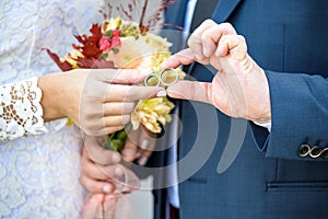 Close-up. Hand of bride and groom. Bride and groom hold hands. Focus on the rings. Bouquet in hand