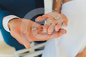 Close-up. Hand of bride and groom. Bride and groom hold hands. Focus on the rings. Bouquet in hand.