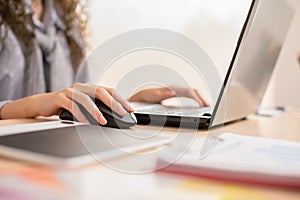 Close up hand of business asian young woman with curly hairstyle holding digital computer mouse and clicking working with computer