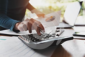 close up hand of business woman using calculator for working