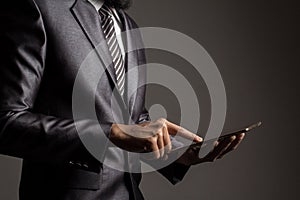 Close up. Hand of businessman in grey suit holding and touching application,Checking the growth rate of the stock market.