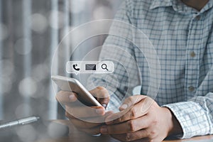 Close up Hand businessman holding silver mobile phone on office deck workplace. checking email message, Searching webpage internet