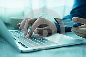 Close up hand of businessmen are buying online with a credit card. Men are using laptop and doing online transactions