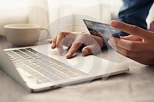 Close up hand of businessmen are buying online with a credit card. Men are using laptop and doing online transactions