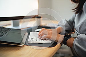 Close up of hand businesswoman typing on keyboard and working laptop on wooden table at home. Entrepreneur woman working for her