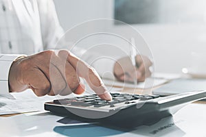 close up hand of businesswoman working on desk in office and using calculator and laptop with pen for calculate. cocept finance