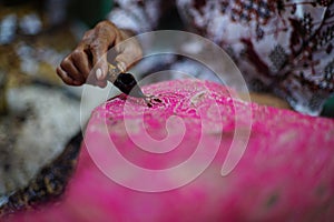 Close Up hand and canting, making batik Tulis Indonesia