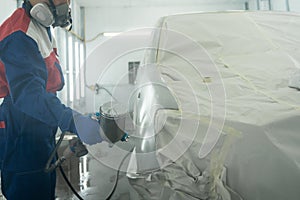 Close-up hand of Car Painting spraying paint in Chamber. automobile repair. Car painter