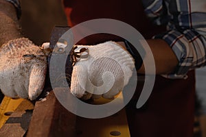 Close-up the hand of carpenter working hard while planing on wood with a manual wood planer or plane tool in workshop or carpentry