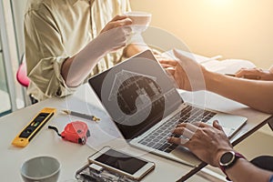 Close up hand of civil engineer or architect business working on blueprint architectural project at construction site at desk in