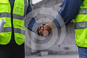 Close-up hand of Civil Engineer with contractor partners are shaking their hands in construction building,