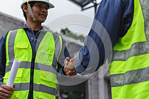 Close-up hand of Civil Engineer with contractor partners are shaking their hands inconstruction building,