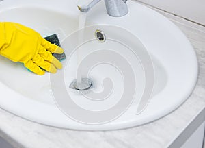Close up on hand cleaning sink with sponge