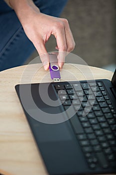 close up hand connecting pendrive in laptop