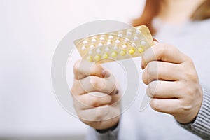 Close up hand contraceptive pill on with colorful pills strips.