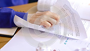 A close-up hand crumples a sheet of paper, an incorrectly written document