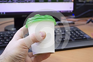 Close-up of Hand with cup of coffee on working place photo