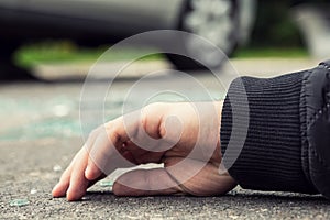 Close-up of a hand of dead person after collision with a car on