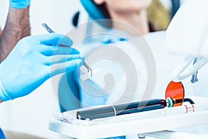 Close-up of the hand of a dentist preparing a dental LED curing