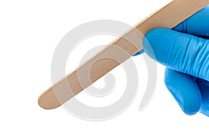 Close up - hand of a doctor holding tongue depressor on white background