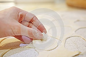 Close-up of hand with dough on background of table with flour. Bake bread. Baking of bakery products