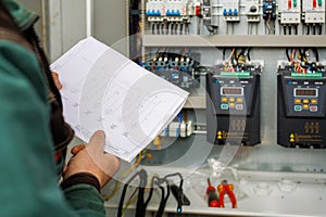 Close up hand of engineer or electrician man working check the electrical system with tablet at factory