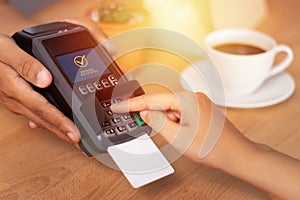 Close up of hand entering credit card pin code for security password in credit card swipe machine at point of sale terminal